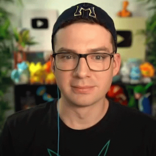 a man in a black shirt wearing glasses and a hat