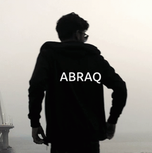 the silhouette of a man wearing a hoodie looking out on the ocean