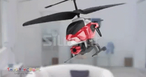 a remote controlled helicopter in flight in an office