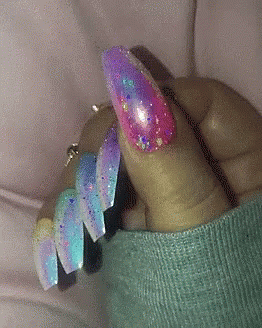 person holding in hand three rainbow colors nail designs