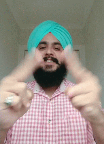 there is a man wearing a turban and pointing to the side
