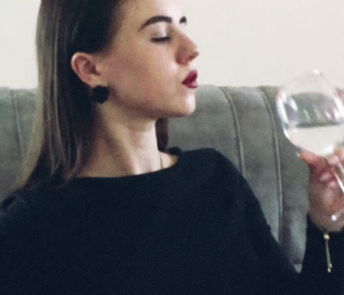a woman holding a wine glass looking to the side
