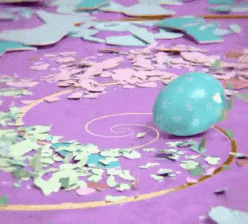 an easter egg sits on a pink background with flowers