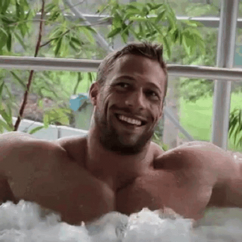 a man smiles while in a  tub