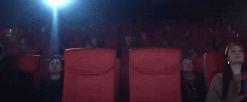 an empty theater seat with two women in white in the middle