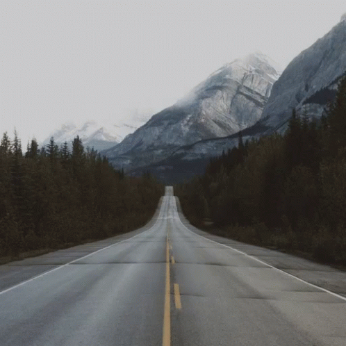 the middle of an empty road in front of mountains