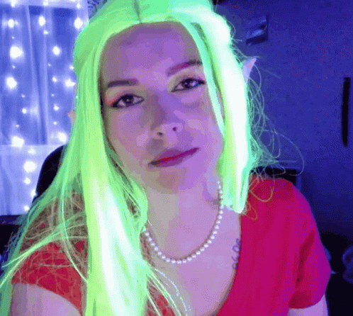a woman with green hair and long white hair wearing pearl necklace