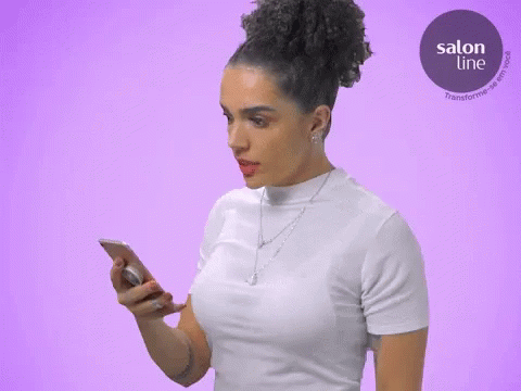 a woman wearing an all white top using a cell phone