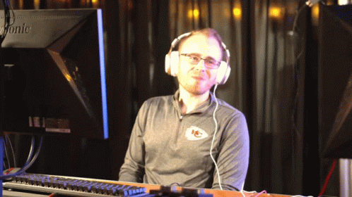 a man wearing headphones with headphones on is next to a keyboard