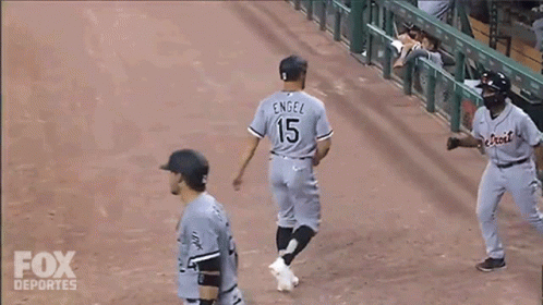 three baseball players congratulate each other after a game