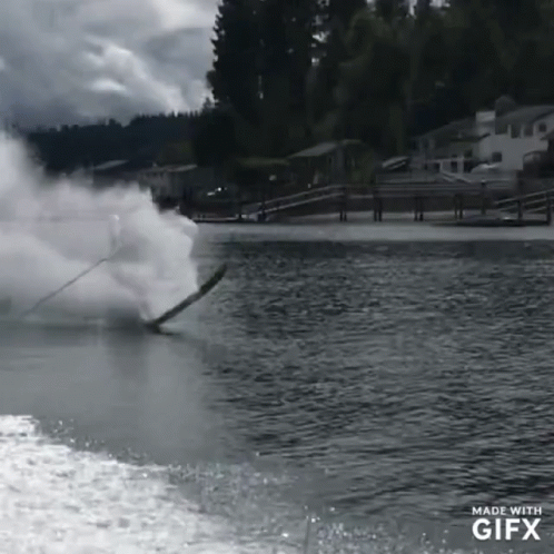 a lake skier has fallen off his ski and is being hit by some large cloud smoke