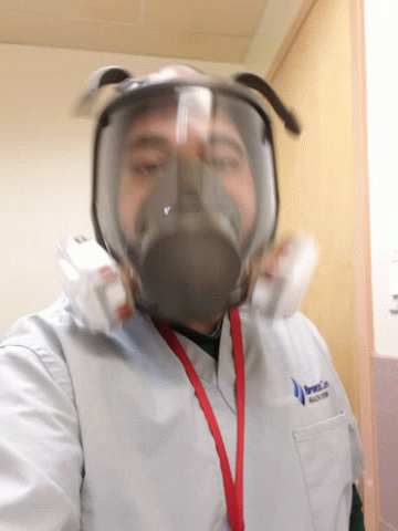 an asian man wearing a gas mask inside a room