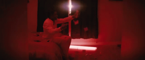 a woman in a white hooded suit in a dark room