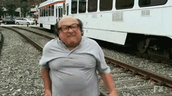 an old man is standing in front of a train