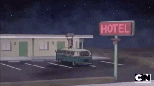 a motel with an older model van is in a motel parking lot