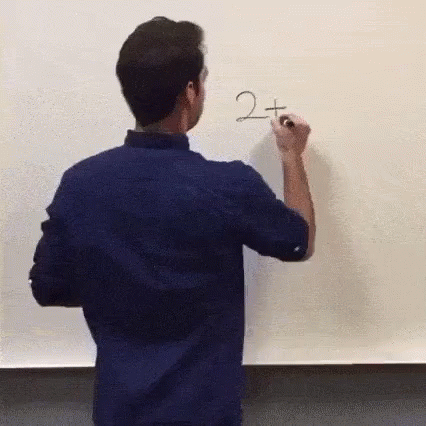 a young man writing on a white board