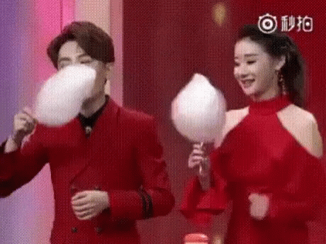 a couple on a show making a joke while holding balloons