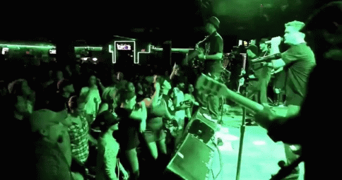 group of people watching man play guitar on stage