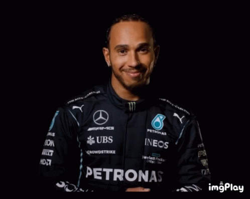 this is a man wearing a racing suit and smiles
