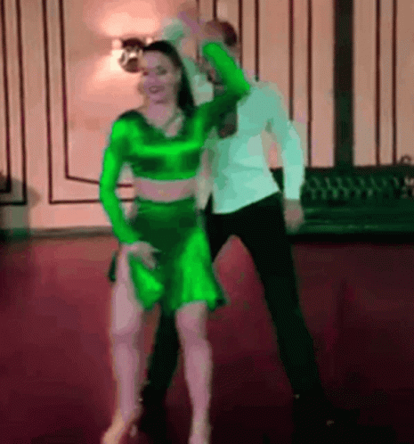 two people dressed in neon outfits are dancing