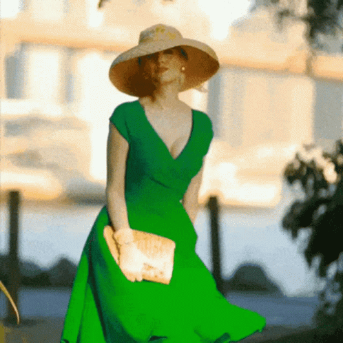 woman in bright green dress walking on sidewalk