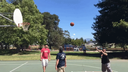 some people are playing basketball on a court