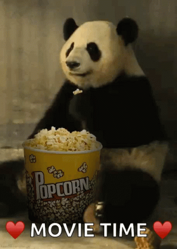 a panda is eating popcorn out of the middle of a bucket