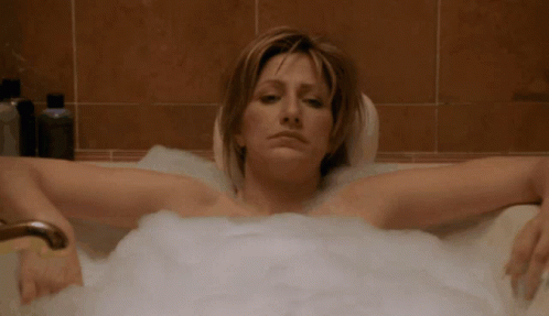 a woman is in a bathtub with foam around her