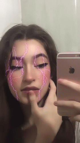 an asian girl with lightning makeup looks at her cellphone