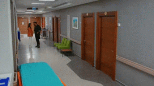 two men walk through a hospital corridor