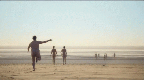 a man running towards a beach while other people are at the edge