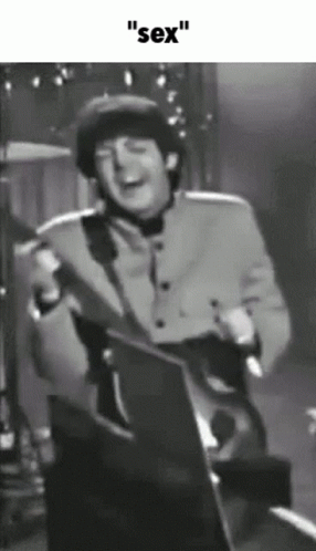 a man in a brown jacket holding a guitar