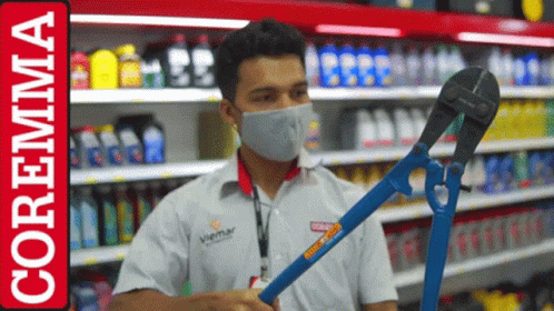 a store worker with a face mask is holding a shovel