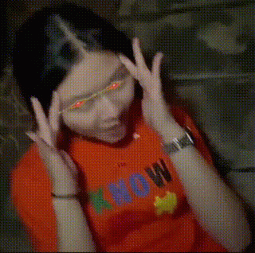 girl with glow on eyes making a gesture while holding her head up