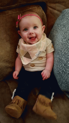 a baby wearing a white shirt with a bib on