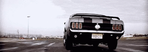 a mustang truck driving on a paved road