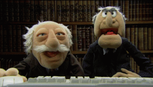 two cartoon characters at a computer keyboard with a computer in front of them