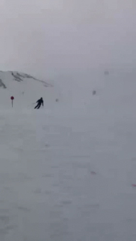 several people are skiing in the distance and on the snow