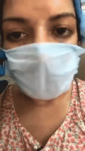 a woman wearing a white face mask to protect her corona