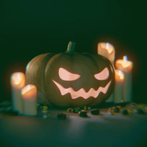 there is a lit jack - o - lantern and candles