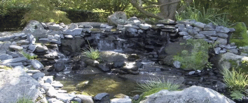 an artificial pond sits on a rocky bank