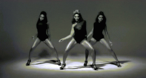 three woman wearing black performing an artistic dance move