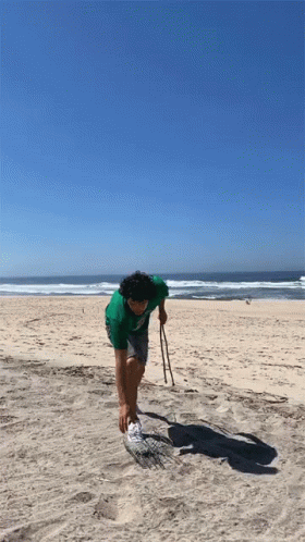man walking on the beach with ski poles in hand
