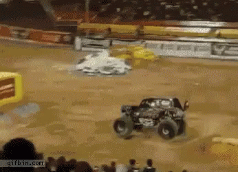 two trucks are driving around in a water filled arena