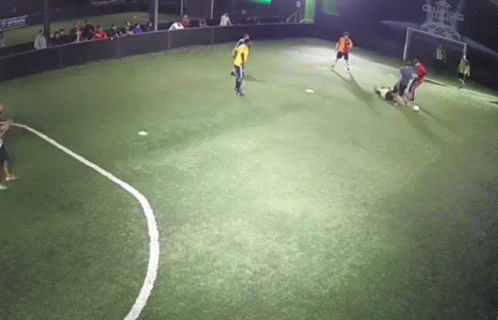 people are playing soccer at night in the dark