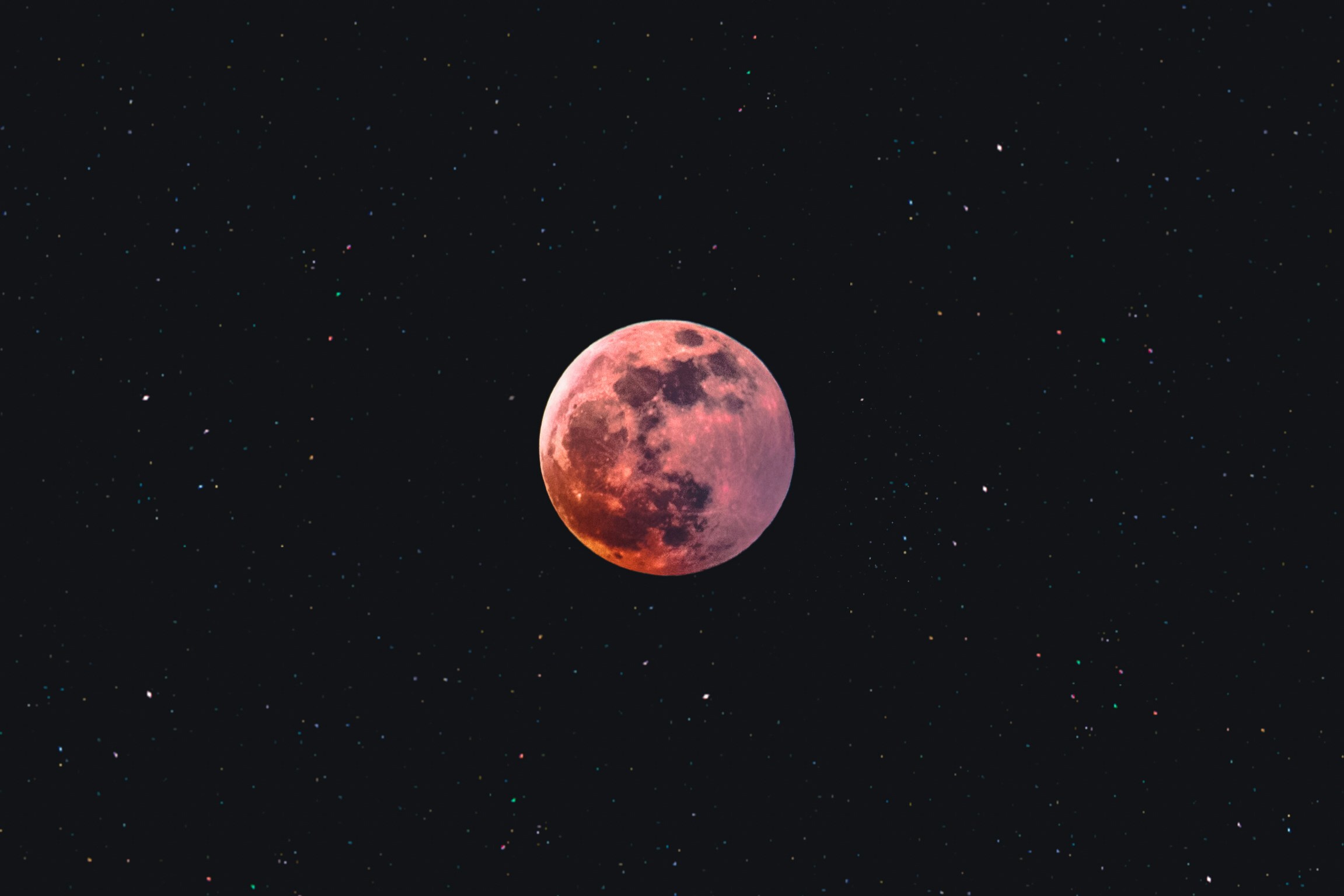 the moon that is red is shining down in the sky