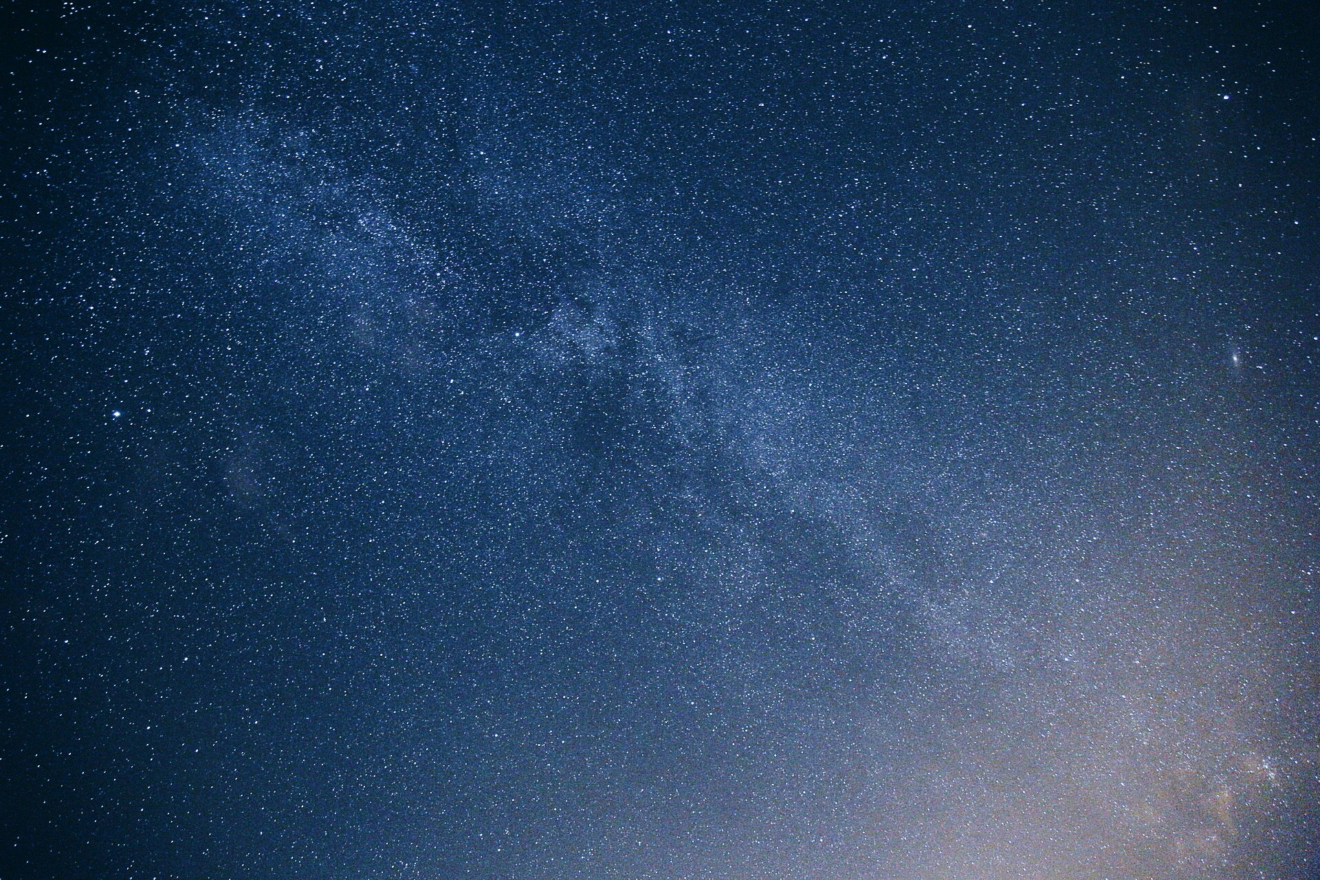 a night sky with small stars and a line of snow