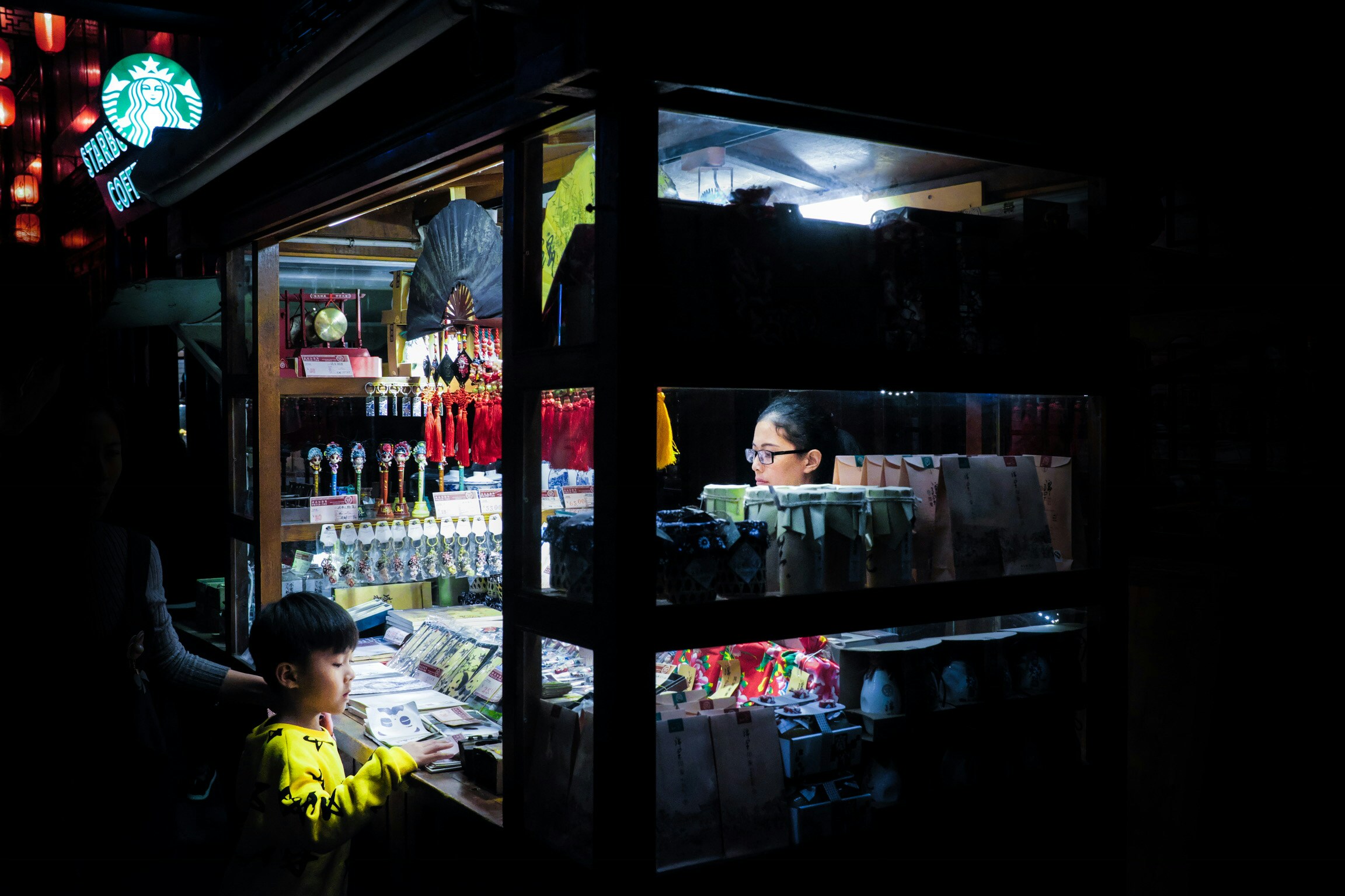 people shopping in an oriental market at night