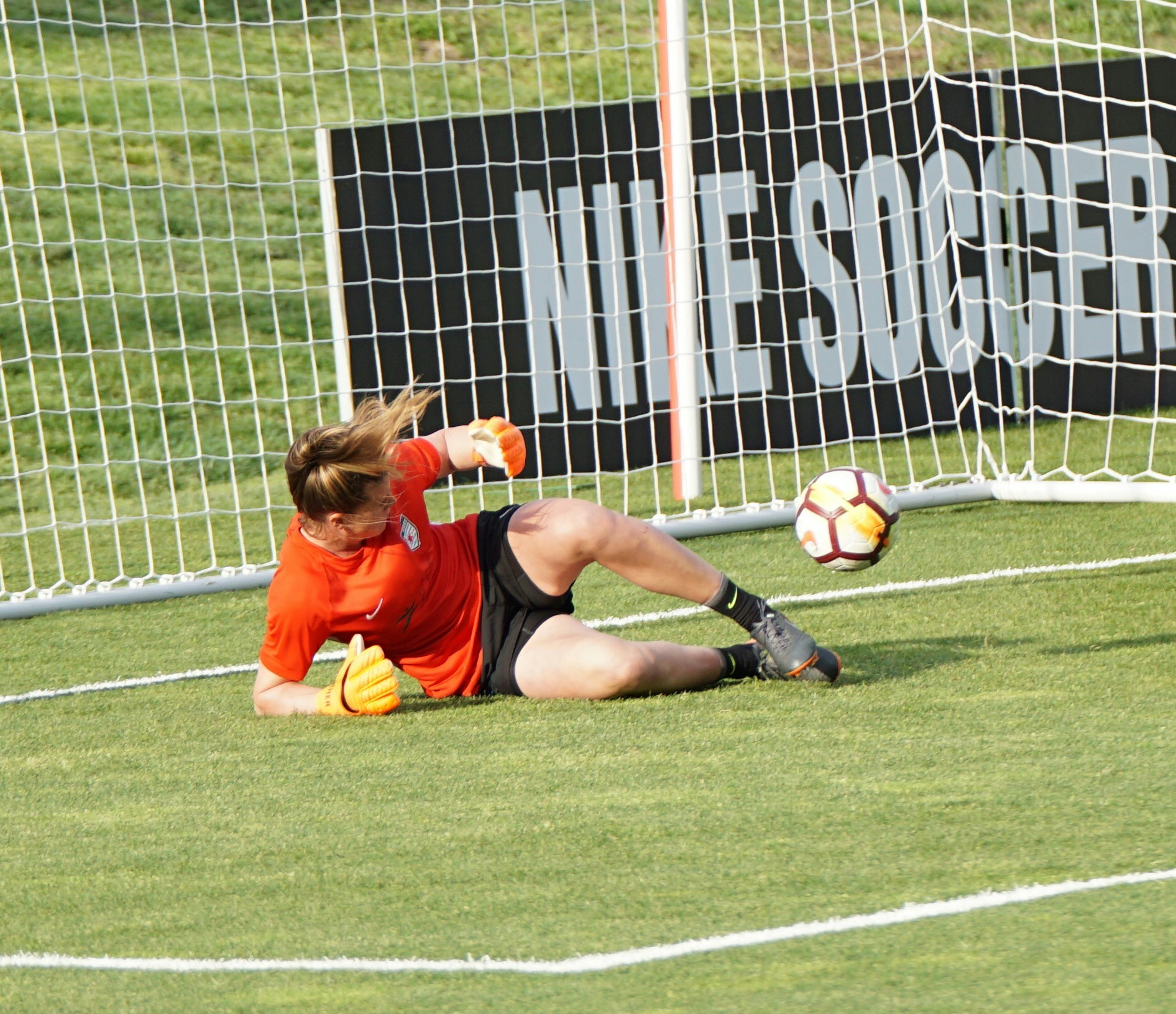 a female soccer player kneeling down on the field