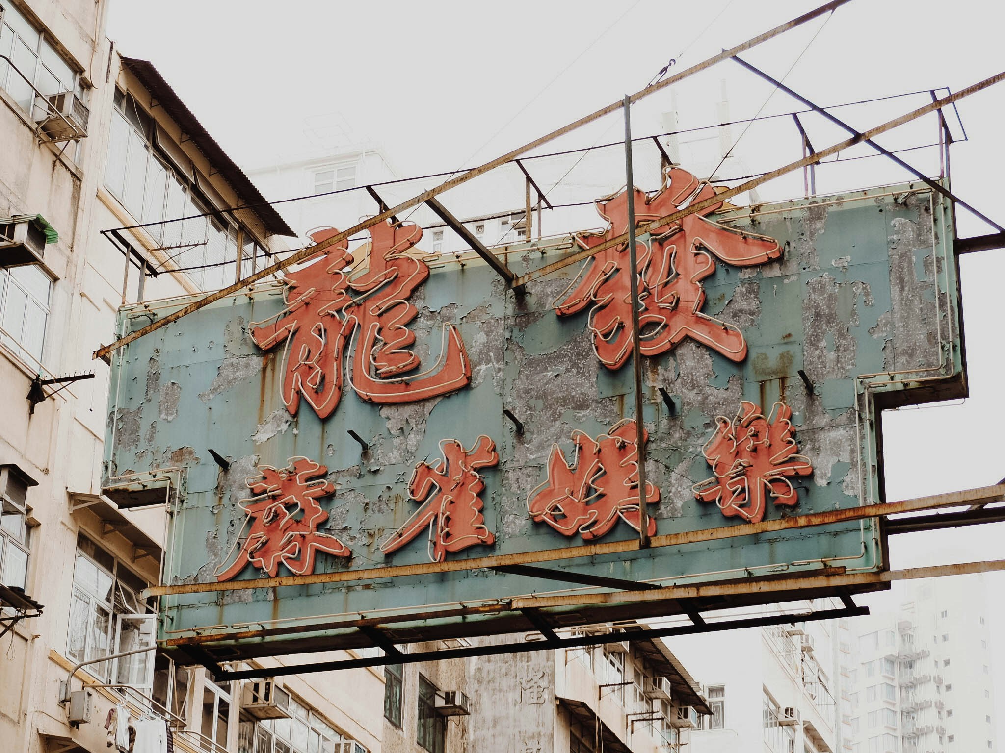 a chinese sign for a shop hanging from a metal structure